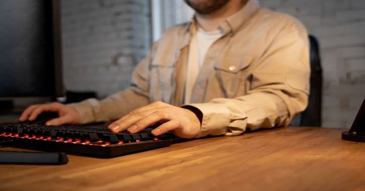 Person using a computer keyboard for typing and office work.