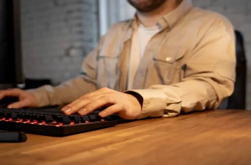 Person using a computer keyboard for typing and office work.